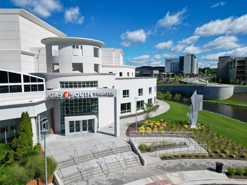 Modern white Gas South Theater building exterior with landscaped grounds and pond