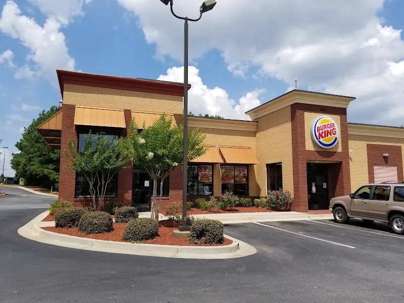 Burger King restaurant exterior with brick facade, landscaping, and parking lot.