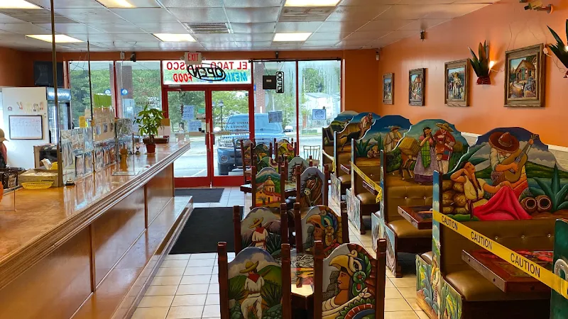 Interior of El Taco Jalisco Mexican restaurant with colorful painted booths and counter.
